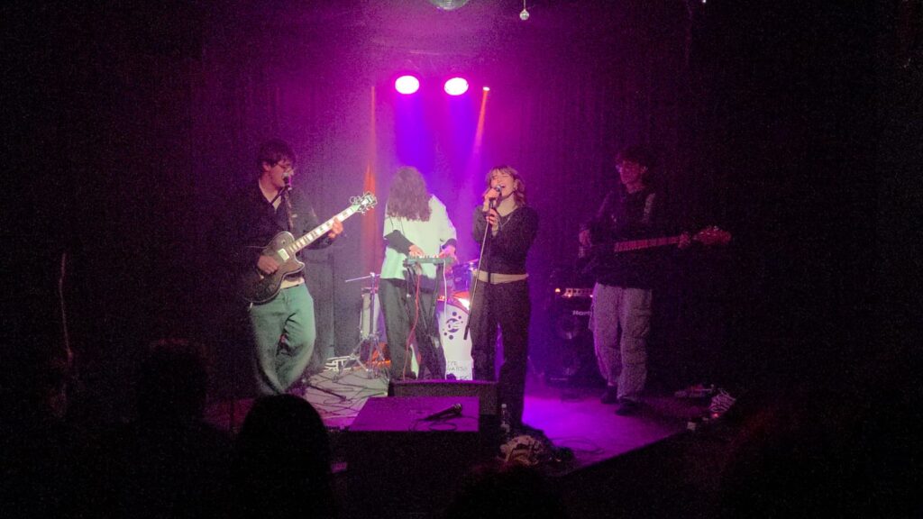 Band al completo sul palco tra luci viola